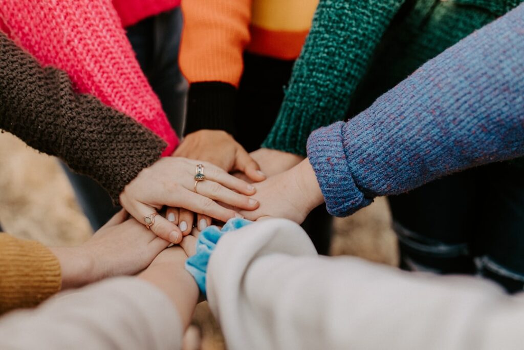 Community members placing their hands together in unity
